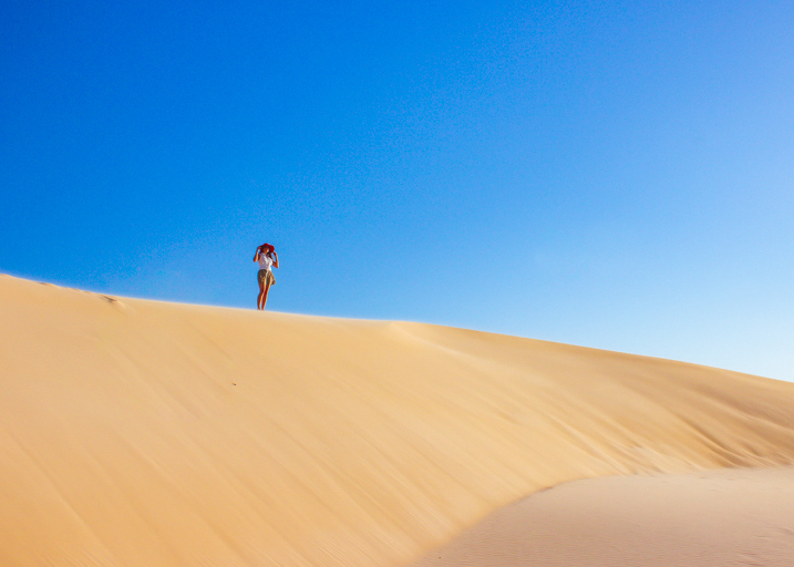 Girl with red hat standing on sand dune while kayak camping upper noosa river