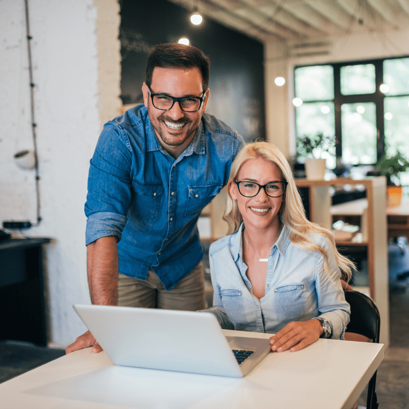 Two business owners in front of a laptop.