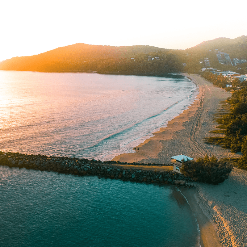 An aerial view of Main Beach during sunset in Noosa, Queensland, Australia.